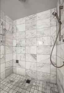 a bathroom with a shower with a marble wall at Luxury Hotel Suite With Private Strip View Balcony in Las Vegas