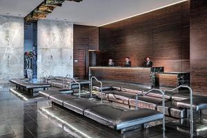 a waiting room with leather benches and a bar at Luxury Hotel Suite With Private Strip View Balcony in Las Vegas