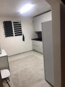 eine Küche mit einem Kühlschrank und Fliesenboden in der Unterkunft SCI AZUR in Basse-Terre