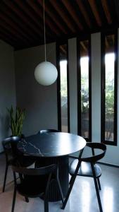 ein Esszimmer mit einem Tisch, Stühlen und einer Lampe in der Unterkunft Luxurious Guest House on beautiful ranch in Medellín