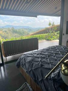 a bedroom with a bed and a view of the mountains at Luxurious Guest House on beautiful ranch in Medellín