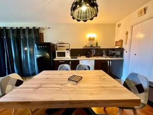 eine Küche mit einem Holztisch mit Stühlen und einem Esszimmer in der Unterkunft Les Xettes, bel appartement style chalet avec vue in Gérardmer
