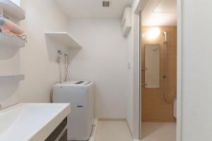 a white bathroom with a toilet and a shower at Tokyo Sunshine Tower in Tokyo