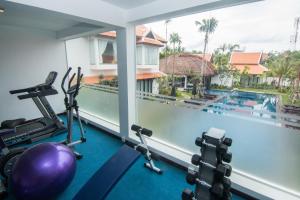 a fitness room with a swimming pool and gym equipment at The Embassy Angkor Resort & Spa in Siem Reap