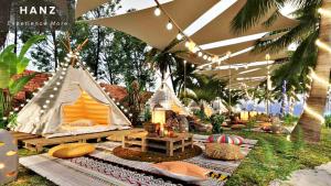 Ấp Thiện Sơn的住宿－HANZ Sun Sea Glamping & Beach Resort，帐篷配有圆锥形帐篷和带灯的帐篷