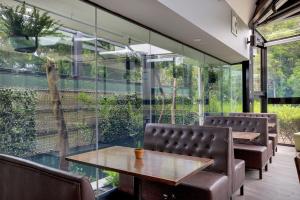 a dining room with glass walls and a table and chairs at Native Rose Hotel in Sydney