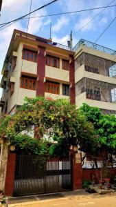 un edificio con un árbol delante de él en Taz Garden House en Dhaka