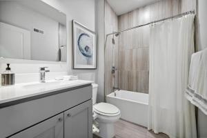 a white bathroom with a toilet and a sink at Luxurious Condo with Rooftop and Parking near University City in Philadelphia