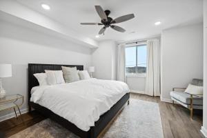 a white bedroom with a bed and a ceiling fan at Luxurious Condo with Rooftop and Parking near University City in Philadelphia