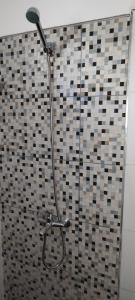 um chuveiro na casa de banho com uma parede em azulejo em Casa Atlántida 2 Dorm. Deck con Parrillero, 3 de Playa Mansa em Atlántida