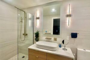 a white bathroom with a sink and a shower at Bright, airy, luxe hideaway”w” private backyard in Brooklyn