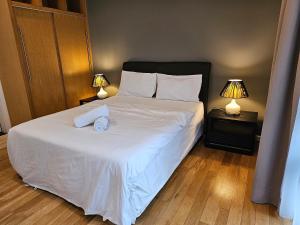 a bedroom with a large white bed with two lamps at St Mary Residences Jalan Tengah in Kuala Lumpur