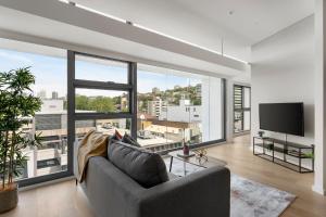 een woonkamer met een bank en een groot raam bij Urban Rest Double Bay Apartments in Sydney