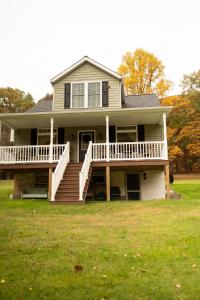 a large house with a porch and a large yard at Historic Sears River Home (Main Level) on 10 Acres 