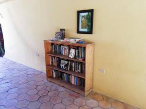 a book shelf filled with books next to a wall at Ecolodge Guancascos, cabaña para 16 personas al pie del PN Celaque in Villa Verde