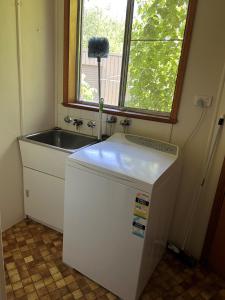 a small kitchen with a sink and a refrigerator at Bridge Motel Wellington in Wellington