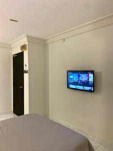 a room with a television on a wall at Andiana Hotel & Lodge - Kota Bharu City Centre in Kota Bharu