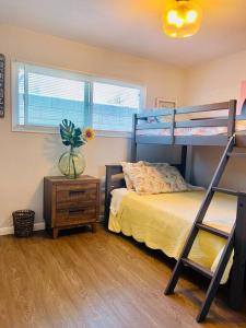 a bedroom with a bunk bed and a table with a vase of flowers at Lovely 2 bedrooms with parking in Carson in Carson