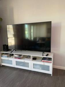 a large flat screen tv on a white entertainment center at Lovely 2 bedrooms with parking in Carson in Carson