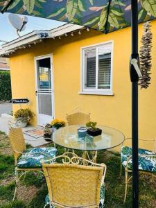 a table with chairs and an umbrella in front of a house at Lovely 2 bedrooms with parking in Carson in Carson