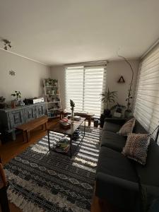 a living room with a couch and a coffee table at Habitación 2 camas + baño privado en Las Condes in Santiago
