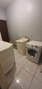 eine Küche mit einer Waschmaschine und einem Waschbecken in der Unterkunft Casa-Ampla Porto Alegre-RS in Porto Alegre
