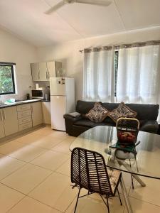 a living room with a couch and a glass table at Cairns Rainforest Retreats in Bellenden Ker