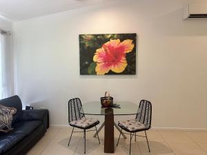 a living room with a table and a flower on the wall at Cairns Rainforest Retreats in Bellenden Ker