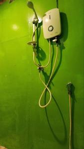 a green wall with a hose hooked up to a blow dryer at Sweet Jungle Bungalows in Koh Rong Island