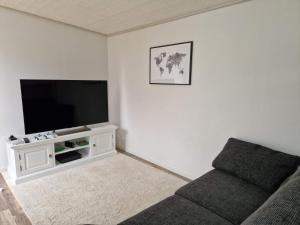 a living room with a couch and a flat screen tv at Holiday home SKÖVDE in Skövde