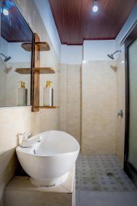 y baño con lavabo blanco y ducha. en Oasis Lembongan en Lembongan