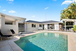 a swimming pool in front of a house at Mermaid Beach Retreat in Gold Coast