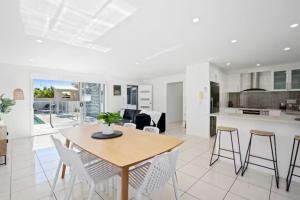 a kitchen and living room with a wooden table and chairs at Mermaid Beach Retreat in Gold Coast