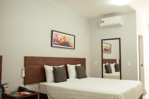 a bedroom with two beds and a mirror at Roma Hotel by H Hotéis - Airport in Brasília