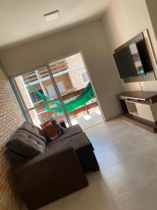 uma sala de estar com um sofá e uma grande janela em Solaris Praia em Luís Correia