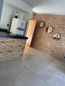 uma cozinha com uma parede de tijolos com relógios em Solaris Praia em Luís Correia