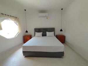 a bedroom with a white bed and a window at Surfers Beachfront Lombok in Kuta Lombok
