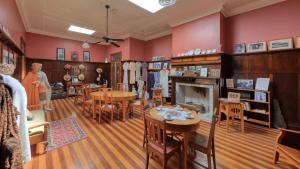 a room with tables and chairs and a fireplace at Hotel Corones in Charleville