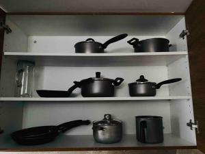 a bunch of pots and pans on shelves in a kitchen at El depart del Franco en Cuenca in Cuenca
