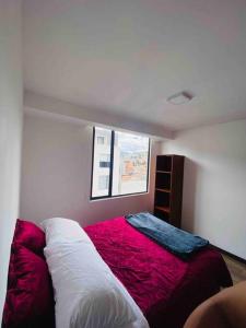 Un dormitorio con una cama roja y blanca y una ventana en El depart del Franco en Cuenca en Cuenca