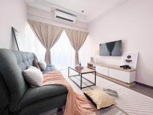 a living room with a couch and a tv at Maison Signature Suites in Kuala Lumpur