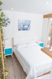 um quarto branco com uma cama e uma janela em Apartamento Loft Edificio Soho 905 em Armênia