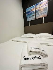 Una cama blanca con dos toallas encima. en K Avenue Seaview Nearby Kota Kinabalu Airport, en Kota Kinabalu