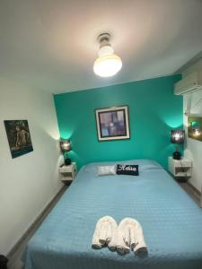 ein Schlafzimmer mit einem Bett mit zwei Hausschuhen darauf in der Unterkunft Temporarios Colón - Habitación Matrimonial in Posadas
