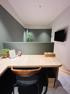 a room with a wooden desk with a chair at it at HOTEL KANMA UENO in Tokyo