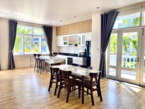 a kitchen and dining room with a table and chairs at Villa Sealink - Căn Hộ Ocean Vista An in Phan Thiet