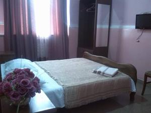 um quarto com uma cama com um ramo de flores em Hostel Georgia em Kutaisi