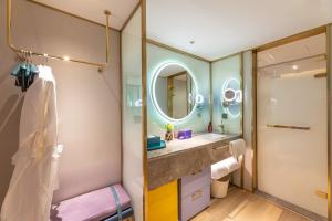 een badkamer met een wastafel en een spiegel bij Man Xin Zhangjiagang Pedestrian Street Hotel in Zhangjiagang