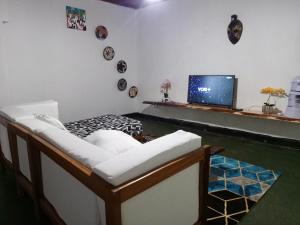 salon z kanapą i telewizorem w obiekcie Akagera guide's House w mieście Kabarondo