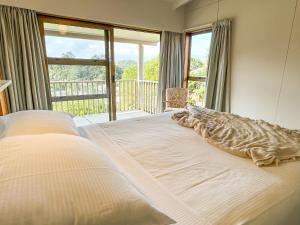 1 cama grande en un dormitorio con balcón en High Tides en Ngunguru